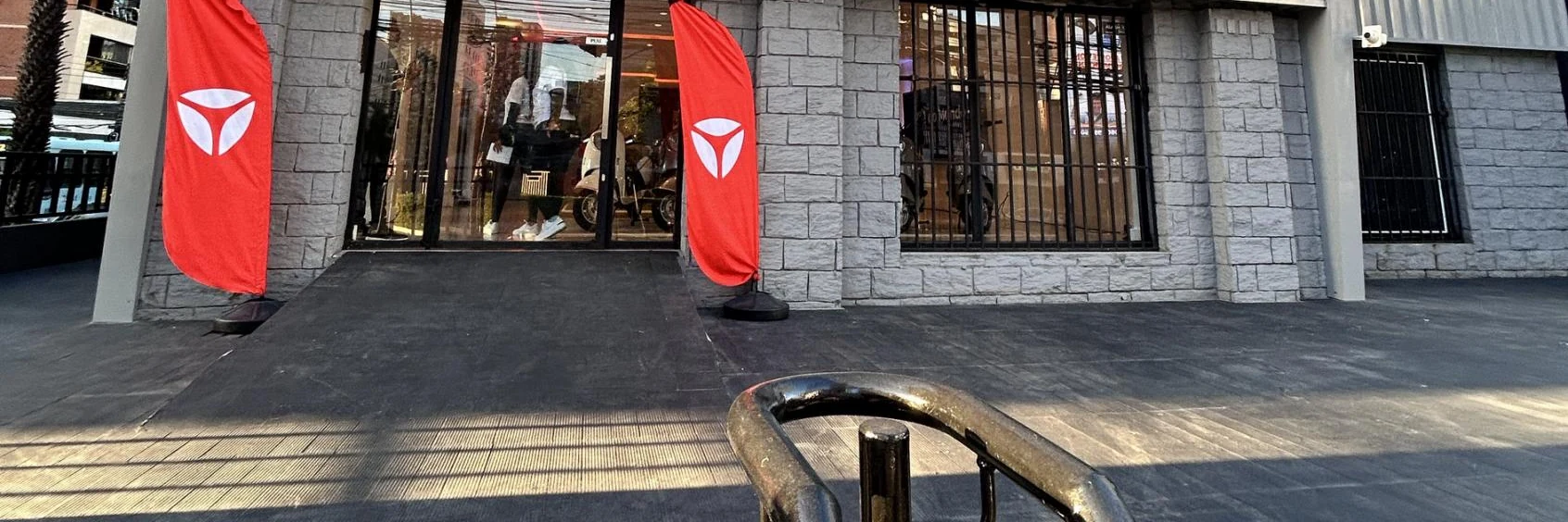 Fachada de loja Yadea com bandeiras na entrada